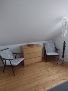 a room with two chairs and a dresser and a dresser at Chata Dvírka in Železný Brod