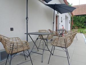 uma mesa e cadeiras com um guarda-sol num pátio em Kafe v obýváku em Bítov