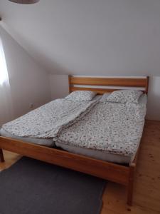 a bed with a wooden frame in a room at Chata Dvírka in Železný Brod
