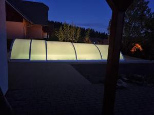 una piscina iluminada por la noche en Villa Gamma - Lipno Home en Lipno nad Vltavou