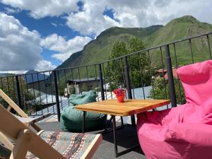 a table and chairs on a balcony with mountains at Four Season In Kazbegi in Stepantsminda