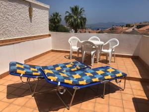 a patio with a table and chairs on a balcony at Puerto de Mazarrón - Large 2 or 3 Bedroom House with Roof Terrace and Wonderful Sea Views in Puerto de Mazarrón