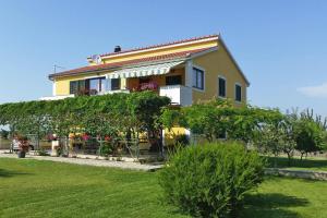 Opatijski Torovi的住宿－Happy Apartments, Biograd，黄色的房子,前面有一个花园