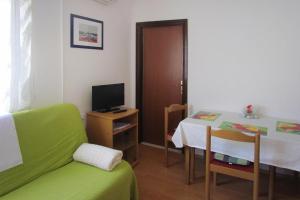 Opatijski Torovi的住宿－Happy Apartments, Biograd，一间设有桌子、床和电视的客房