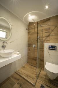 a bathroom with a shower and a toilet and a sink at Golden View Studios in Chrysi Ammoudia