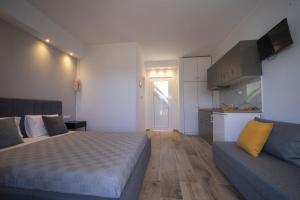 1 dormitorio con 1 cama y 1 sofá en Golden View Studios, en Chrysi Ammoudia