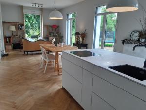 a kitchen with a table and a dining room at Les Tilleuls - Villa année 30 in Sancergues