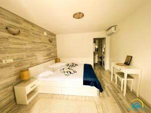 a bedroom with a white bed and a wooden wall at Complex Turistic Casa Anastasia in Murighiol +206 photos