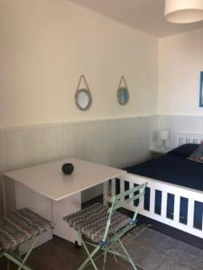 ポルト・チェザーレオにあるCasa Vacanzaのベッド、テーブル、椅子が備わる客室です。