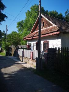 a small white house with a wooden fence at Róza Vendégház in Buják +17 photos