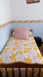 a bed in a room with a blanket on it at Apartamento La Basella in Villanueva de Arosa