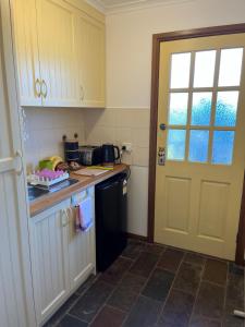 a kitchen with a black refrigerator and a door at Bicheno getaway for two in Bicheno