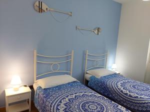 two beds in a room with blue walls at Villa Mimosa Tropea in Ricadi +49 photos