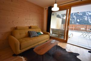 a living room with a couch and a table at VAUJANYLOCATIONS - La Cabane de Maurice in Vaujany
