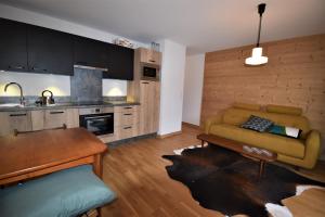 a kitchen and living room with a couch and a table at VAUJANYLOCATIONS - La Cabane de Maurice in Vaujany