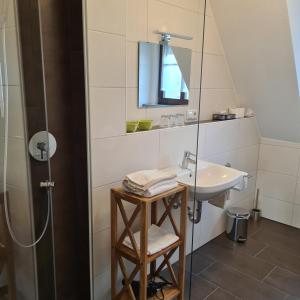 ein Bad mit einem Waschbecken und einer Dusche in der Unterkunft Gasthaus Schöllmann in Feuchtwangen