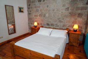 1 dormitorio con 1 cama y 2 mesitas de noche con lámparas en Biber Evi Assos, en Ayvacık
