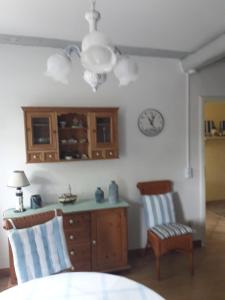 eine Küche mit einem Tisch und Stühlen sowie einer Uhr an der Wand in der Unterkunft Möwe in Steffenshagen
