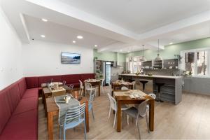 a restaurant with a red couch and tables and a kitchen at Hostel Antique in Pula