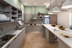 a large kitchen with white counters and a large island at Hostel Antique in Pula