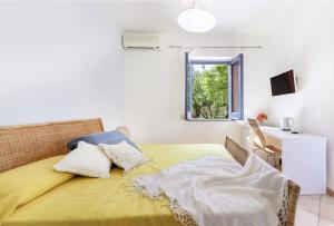 a bedroom with a bed with a yellow blanket and a window at Casa Giovanni da Procida in Procida