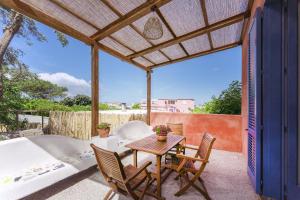 een patio met een tafel en stoelen en een bad bij Casa Giovanni da Procida in Procida