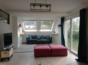 a living room with a couch and a tv at La Toulranaise in Plouescat