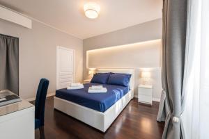 een slaapkamer met een blauw bed met blauwe kussens bij Ponte Vecchio Deluxe Apartments in Florence
