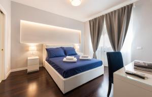 een slaapkamer met een blauw bed en een bureau met een printer bij Ponte Vecchio Deluxe Apartments in Florence