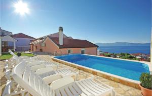 a group of white chairs sitting next to a swimming pool at Awesome Apartment In Podaca With Outdoor Swimming Pool in Podaca