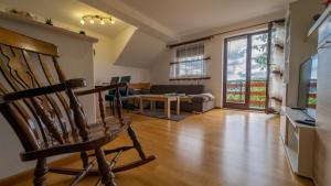- un salon avec une chaise et un canapé dans l'établissement Apartman Suhi vrh, à Ravna Gora