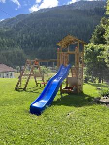 un parque infantil con tobogán y una casa de juegos en Jakob, Landhaus, en Tux