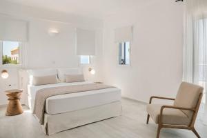 a white bedroom with a bed and a chair at Lourdas White Villa in Kefallonia