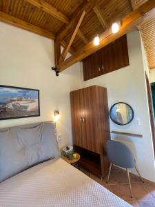 a bedroom with a bed and a cabinet and a mirror at Elenas Studios in Vourvourou