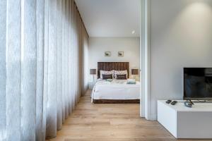 una camera con letto, TV e tende di Antas Park Flat With Pool a Porto