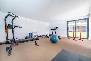 una palestra con diversi tapis roulant e una palla da ginnastica di Antas Park Flat With Pool a Porto