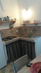 una cucina con lavandino e piano cottura di La casa dei nonni a Pantelleria