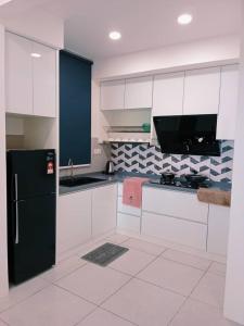a kitchen with white cabinets and a black refrigerator at Preferred30 3R2B 7pax Meritus Perai in Perai
