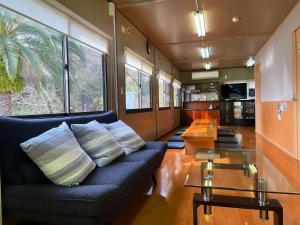 ein Wohnzimmer mit einem Sofa und einem Tisch in der Unterkunft 1棟貸し tbtランド 定員最大12名 in Shodoshima