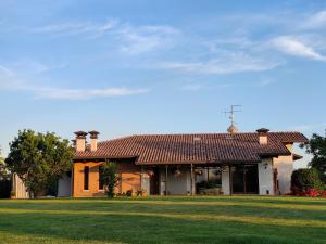 una casa con un césped verde delante de ella en B&B Villa Letizia en San Vito Rimini