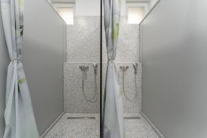 a bathroom with two mirrors and a walk in shower at Hostel Antique in Pula
