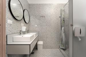 a bathroom with a sink and a toilet and a mirror at Hostel Antique in Pula