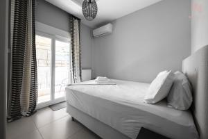 a white bedroom with a bed and a window at Awesome Sea View, Nilie Hospitality MGMT in Thessaloniki