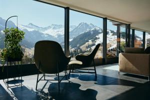 a living room with chairs and a large window at The Cambrian in Adelboden