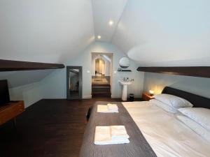 a bedroom with a large bed with two towels on it at Le Petit Château in Baye