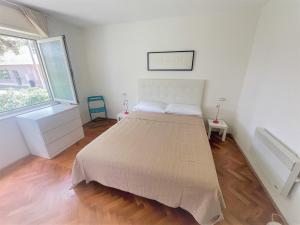 een bed in een witte kamer met een groot raam bij Faber Apartments in Novigrad Istria