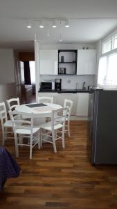 een keuken met een witte tafel en stoelen bij Appartement Grün-Weiß in Sankt Englmar