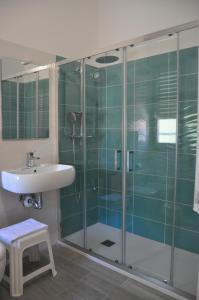 La salle de bains est pourvue d'une douche en verre et d'un lavabo. dans l'établissement Hotel Susy - Ambienti rinnovati - direttamente su viale Dante e a due passi dal mare, à Riccione