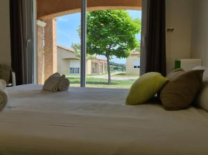 um quarto com uma cama e uma janela grande em Park & Suites Village Gorges de l'Hérault-Cévennes em Brissac