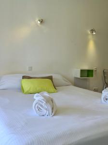 a white bed with two towels on top of it at Park & Suites Village Gorges de l'Hérault-Cévennes in Brissac